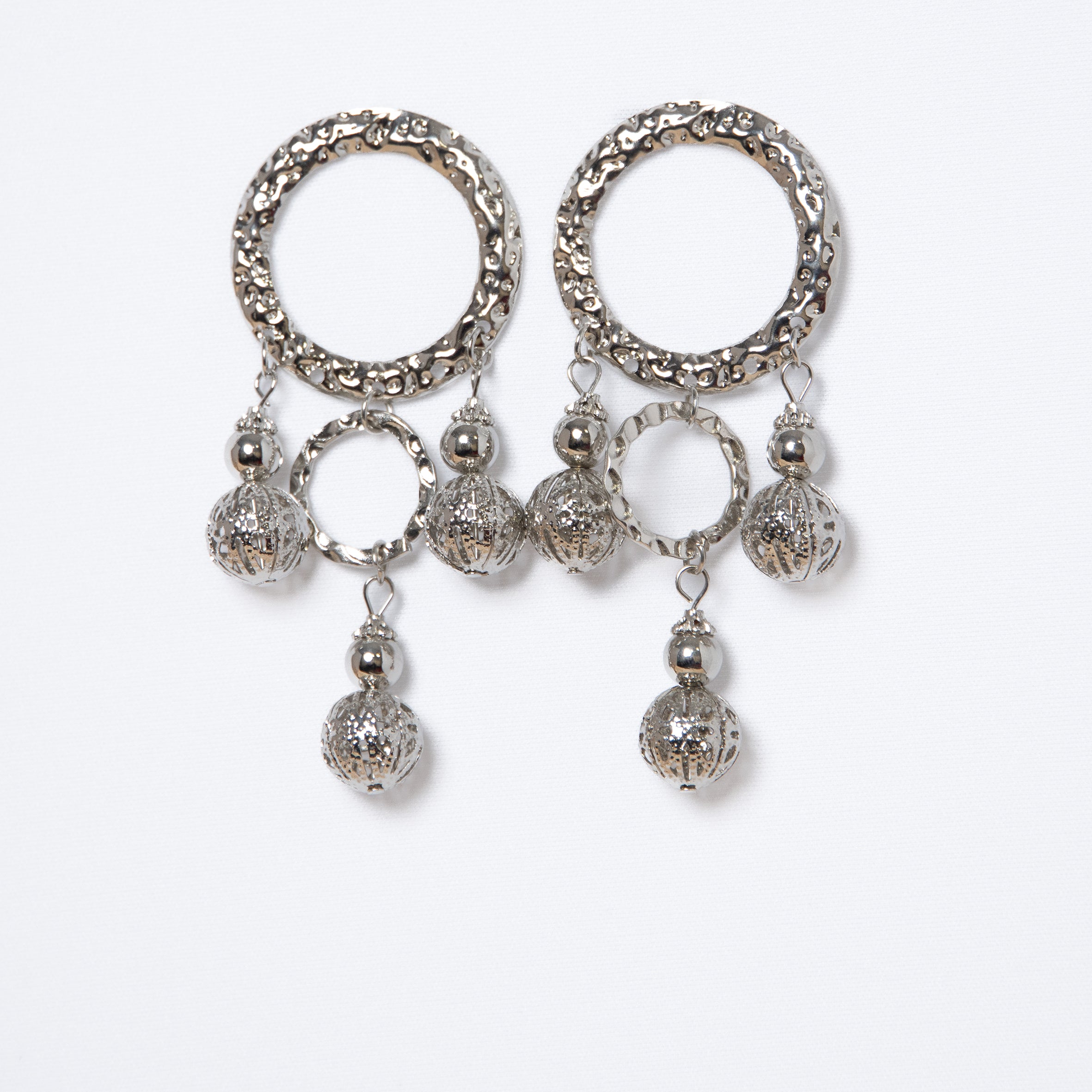 Pendientes largos plateados con aros y bolas caladas